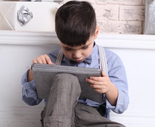 happy-young-boy-sitting-on-the-floor-using-a-tablet-picture-id1213155783